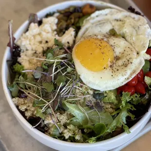 a bowl of food with a fried egg on top