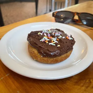 a chocolate frosted donut with sprinkles