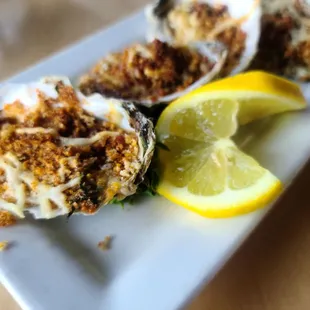 a plate of oysters with a lemon wedge