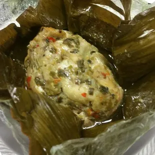 Catfish and tilapia with greens and flavorings in banana leaf.