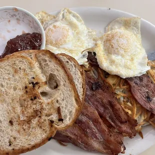 2 Eggs , 4 thick slices of bacon , half a plate of hash browns with toast and jelly . $8