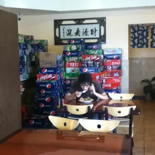 Soda cases line the walls. Eating while gabbing on the cell phone is perhaps less gross than eating while texting.