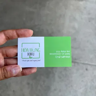 a hand holding a business card