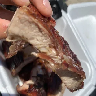 a hand holding a piece of meat