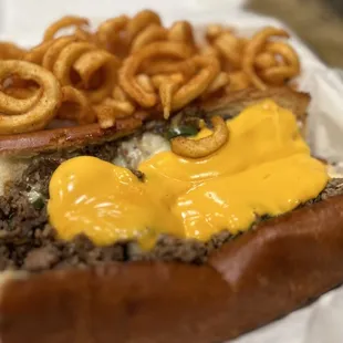 a hamburger with cheese and onion rings
