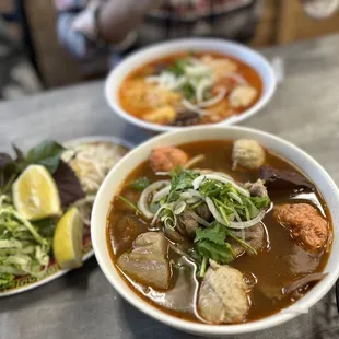 two bowls of soup and a salad