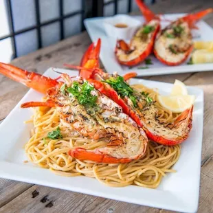 two lobsters on a bed of noodles