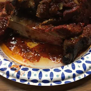 a plate of ribs and sauce