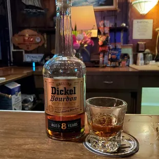 a bottle of whiskey and a glass on a bar