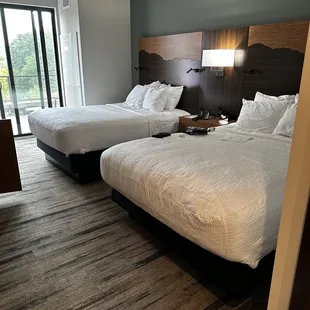 Two queen beds and patio access.