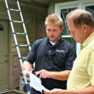 two men standing in front of a house