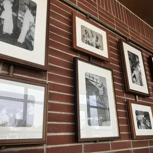 a brick wall with framed photos