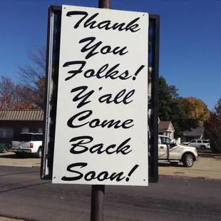 a thank you folks sign on a street corner