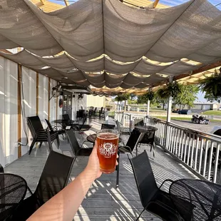 a person&apos;s hand holding a pint of beer