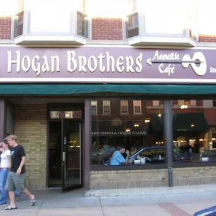two people walking in front of a restaurant