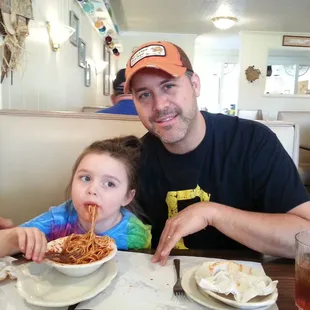 a man and a little girl eating spaghetti