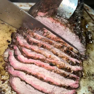 the meat being sliced on a cutting board