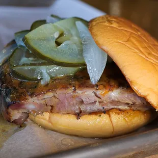 Pig Rib Sandwich. Columbus Original BBQ Sauce, Quarter Rack of Ribs, Bread and Butter Pickles, on top of a garlic butter grilled Potato Bun.