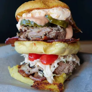 The Pig Mac. A triple decker sandwich with Pulled Pork, Bacon, Tomato, Cole Slaw, Dill Pickles, Mac Sauce, and Pimento Cheese.