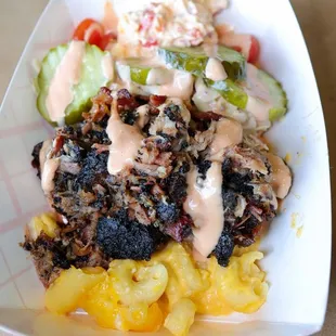 Pig Mac Bowl. Pulled Pork, Dill Pickled, Cole Slaw, Tomatoes, Mac Sauce, and Pimento Cheese on a bed of Mac and Cheese.