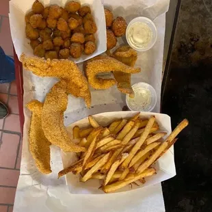 CATFISH dinner served with a side of okra and French fries along with hush puppies and tartar sauce