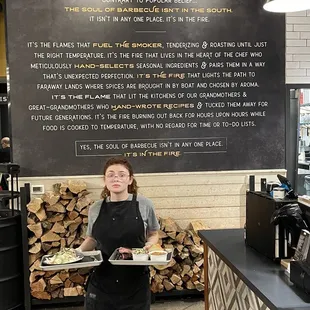 a woman holding two trays of food