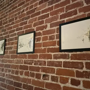 brick wall with three framed prints