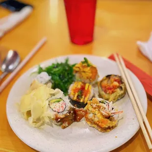 a plate of sushi with chopsticks