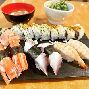 a variety of sushi on a black plate