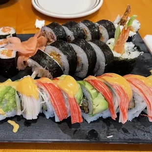 a variety of sushi on a black plate