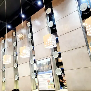 Interior decorated with pendant lights and ramen bowls.