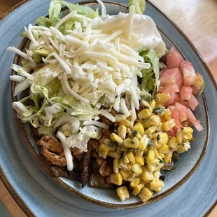 Springfield Bowl. Grilled chopped chicken, steak, shrimp, lettuce, sautéed onions, bell peppers, street corn, cheese