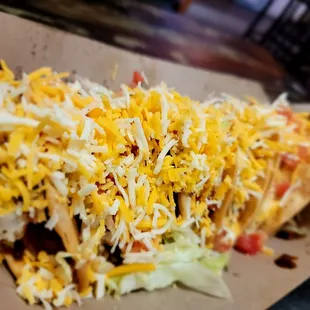 a plate of tacos with cheese and lettuce