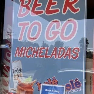 a beer to go sign in a window