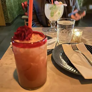 a woman sitting at a table with a drink