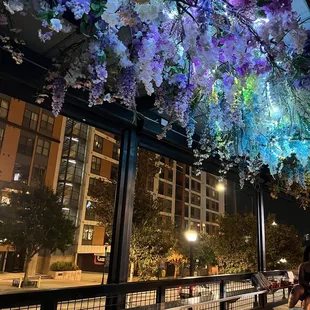 people sitting at tables under flowers