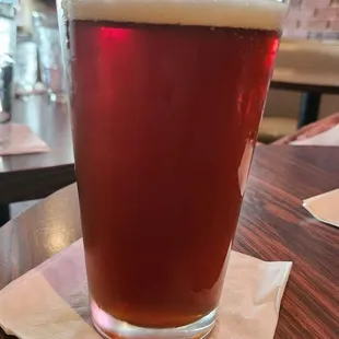 a glass of beer on a napkin