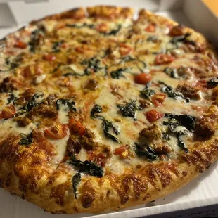 Pizza with Italian sausage, spinach and tomato