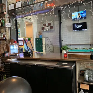 a bar with christmas lights and a television