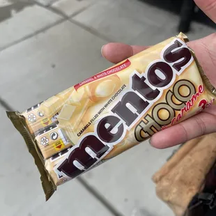 a hand holding a chocolate bar