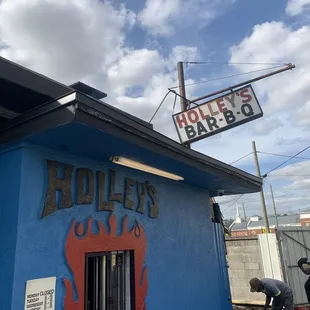a blue building with a sign that says holley's bar b q