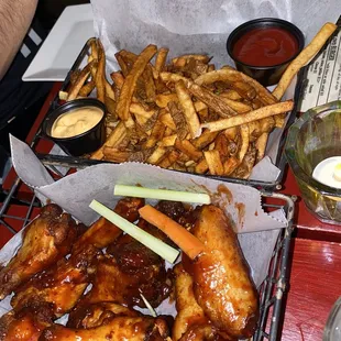 a basket of chicken wings and french fries