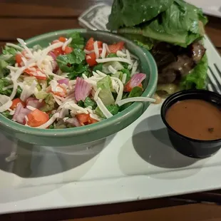 Lettuce wrapped spicy smash burger with a salad.