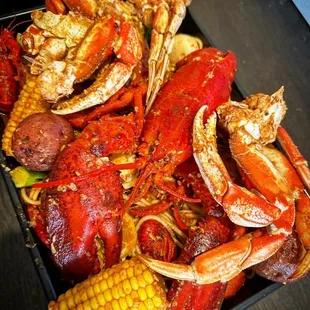 crab legs, corn, potatoes, corn on the cob