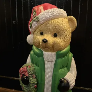 a teddy bear in a green vest and hat