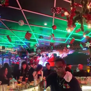 View from the side of the bar. Lights on the ceiling sync with the Christmas Carols playing on the big screen in the back.