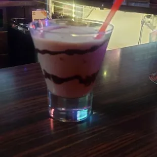 a glass of milkshake on a bar