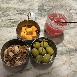three bowls of fruit, nuts, and a drink