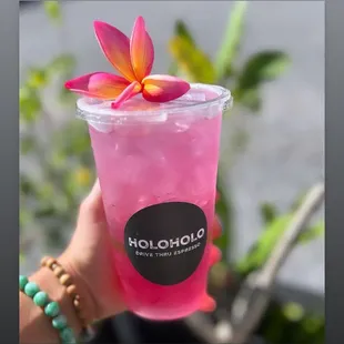 a hand holding a pink drink