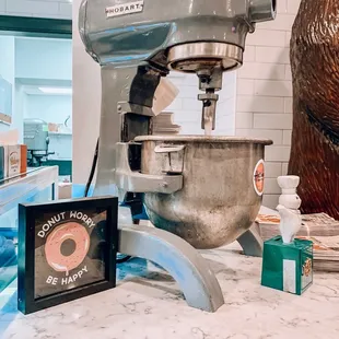 a doughnut machine and a sign